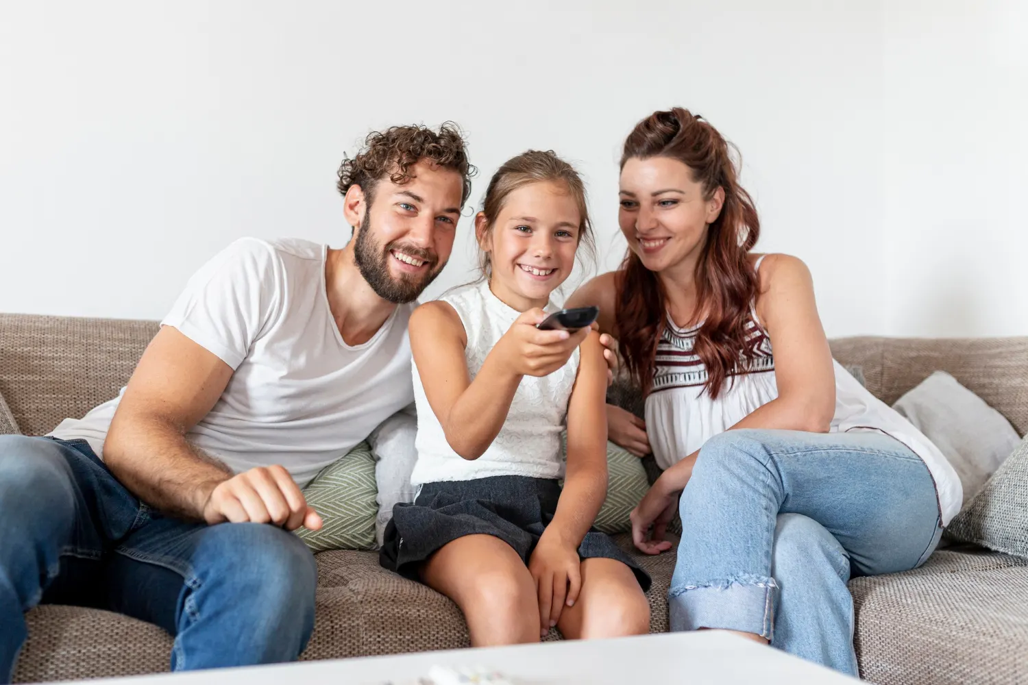 Une famille regarde la télévision ensemble à la maison sur le canapé